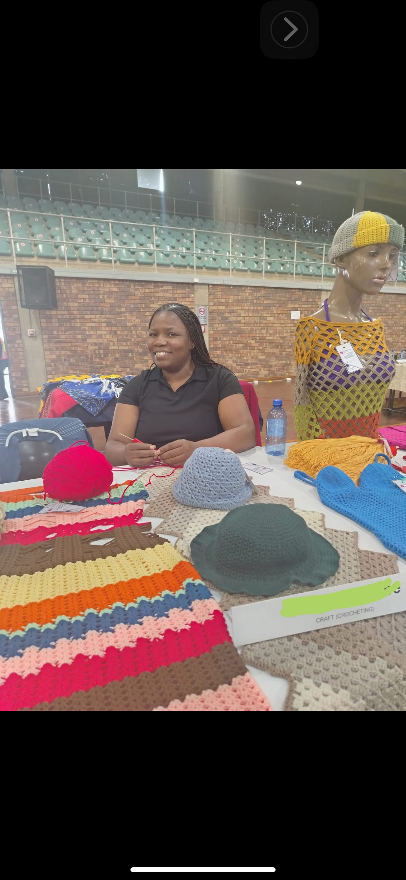 Mampe Maria Radebe, founder of Thabonaka Wool Trend, knitting at her stall